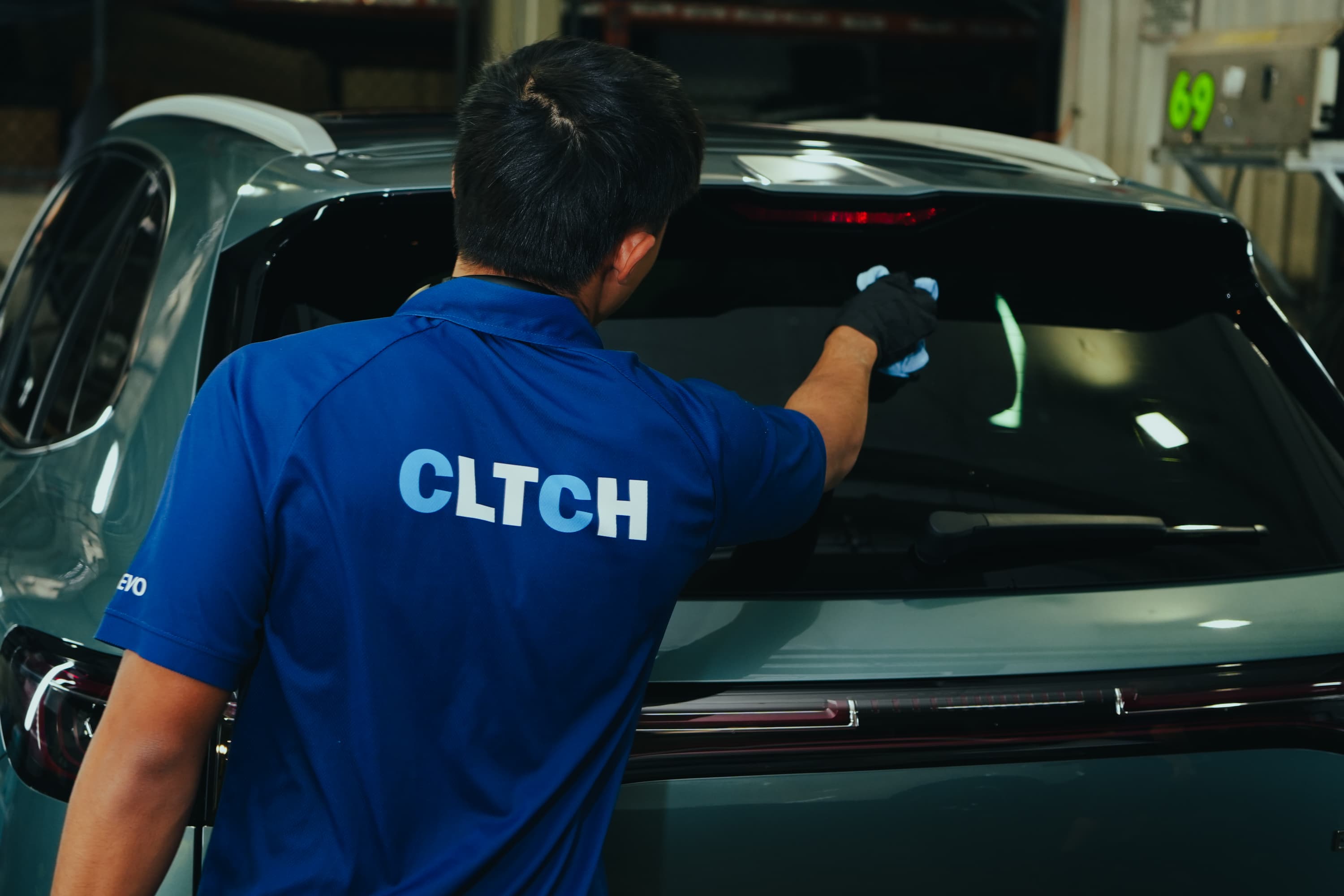 CLTCH technician finishing the rear glass on prepared stock