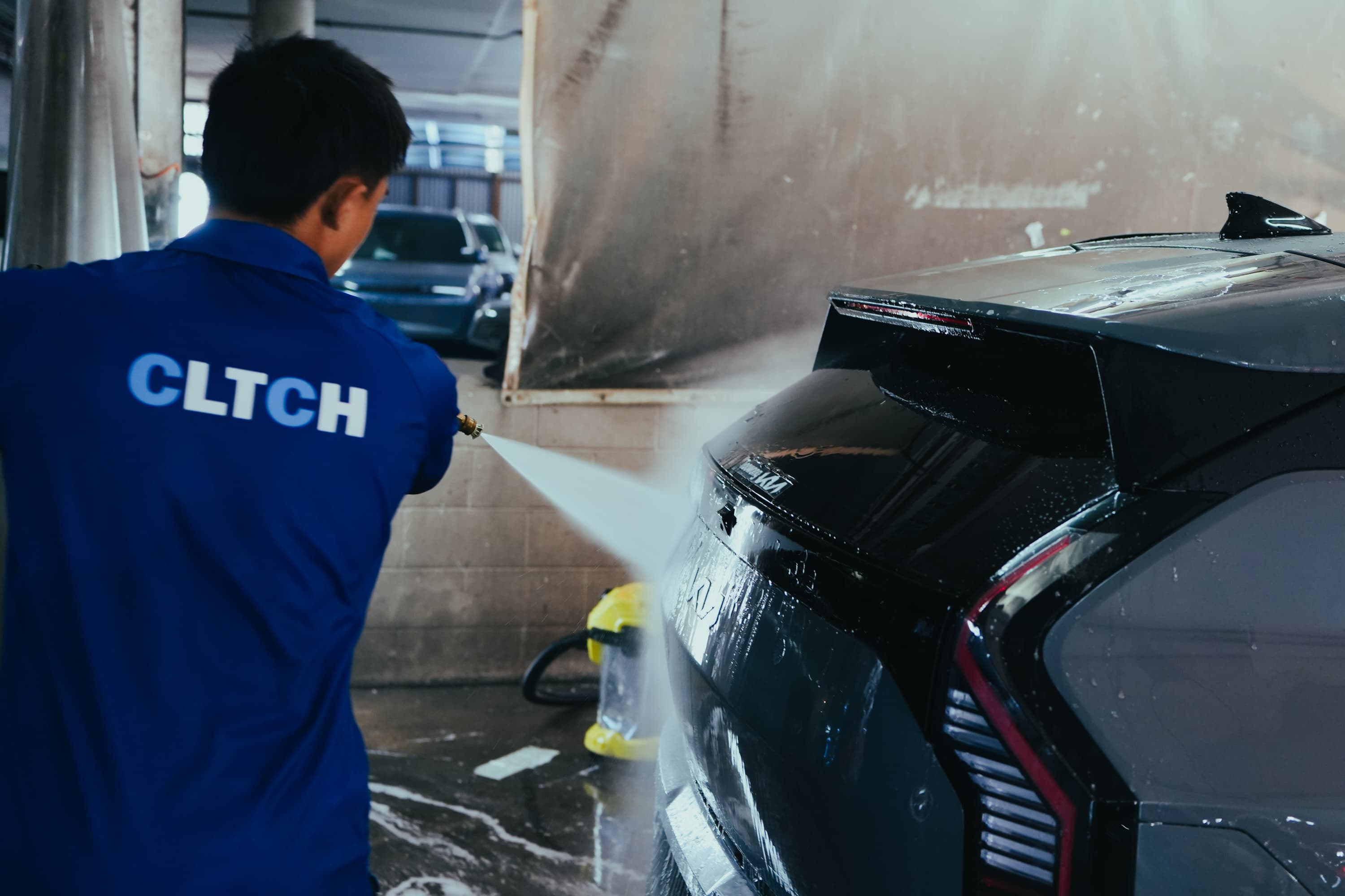 CLTCH technician pressure-washing a vehicle between hires