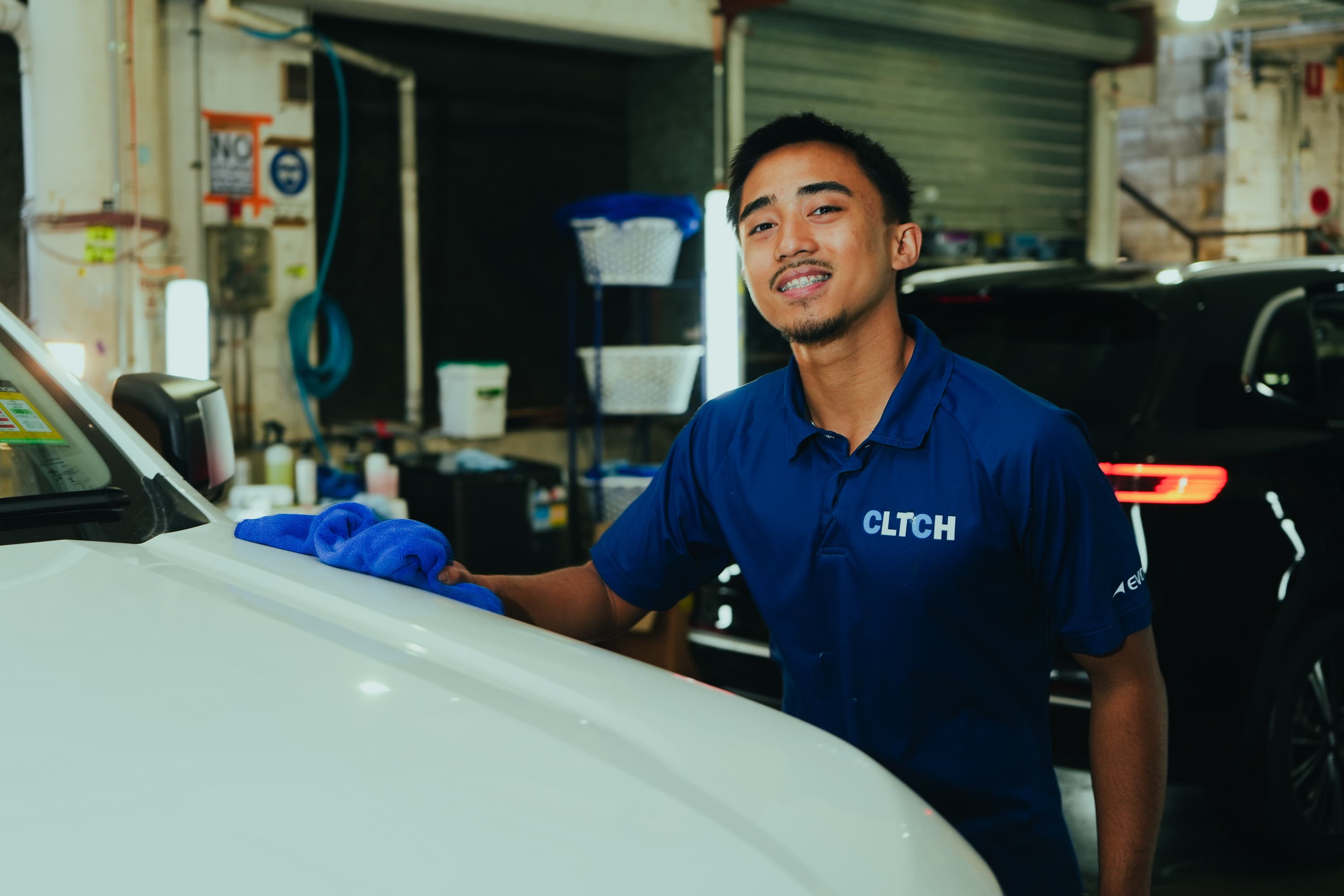 CLTCH crew member smiling while prepping a ute