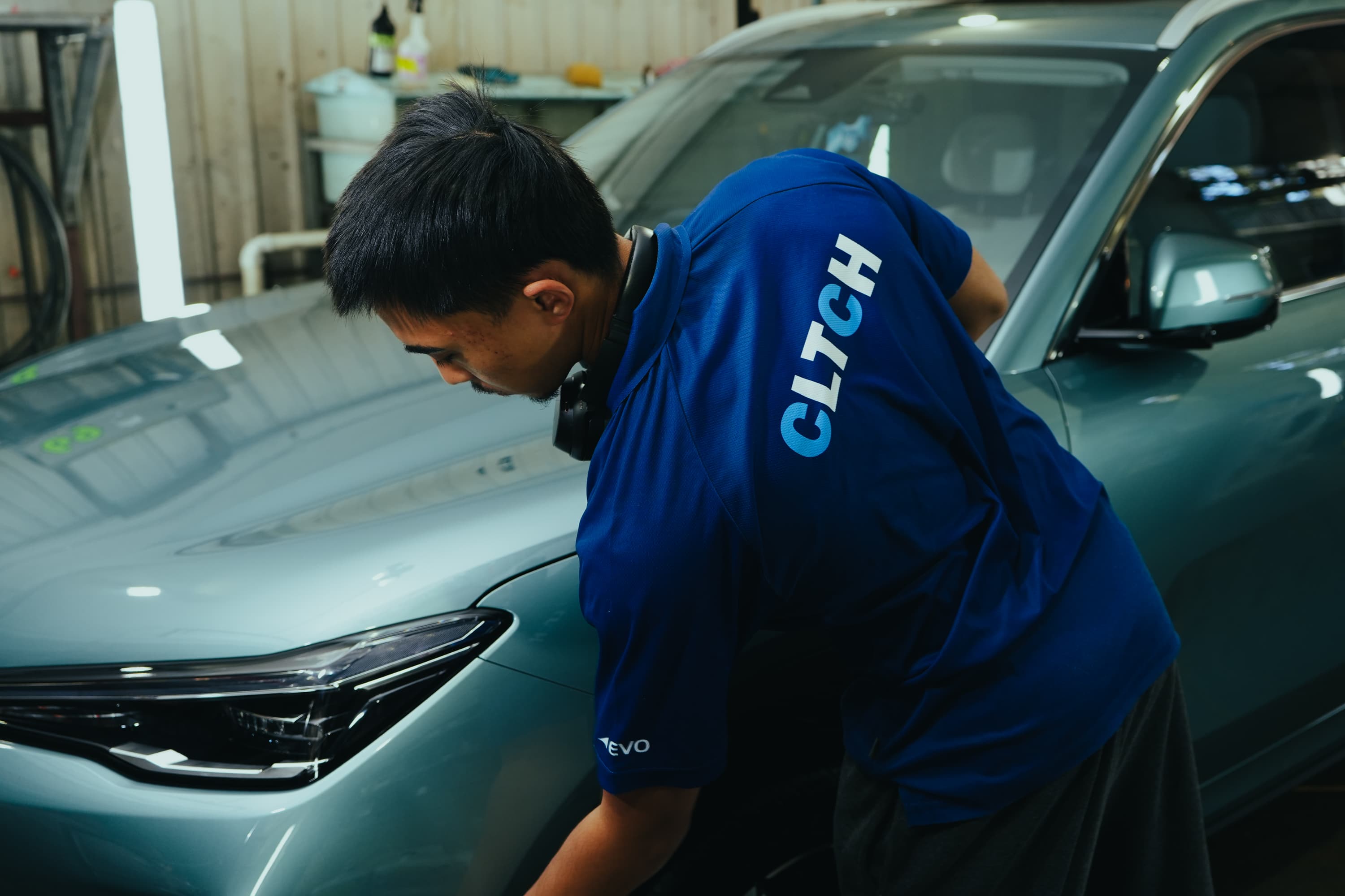CLTCH detailer working over a bonnet and headlight